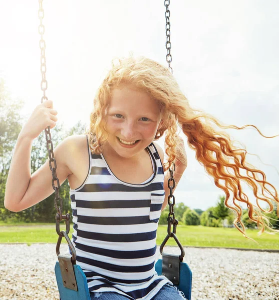 晴れた日は揺れている 公園でスイングで遊んでいる若い女の子の肖像画 — ストック写真