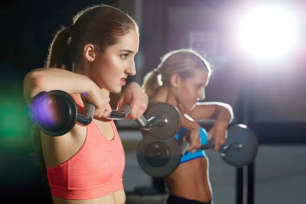 两个年轻女子在健身房练举重 — 图库照片