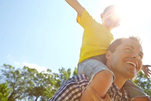 Babaların Omuzlarında Uçmak Oğlunu Omuzlarında Taşırken Güneşe Gülümseyen Genç Bir — Stok fotoğraf