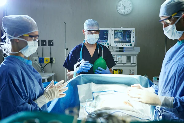 命を救うために協力する 手術室の外科医は — ストック写真