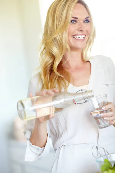 Stock image Staying healthy and hydrated. Attractive young blonde woman pouring herself a glass of water