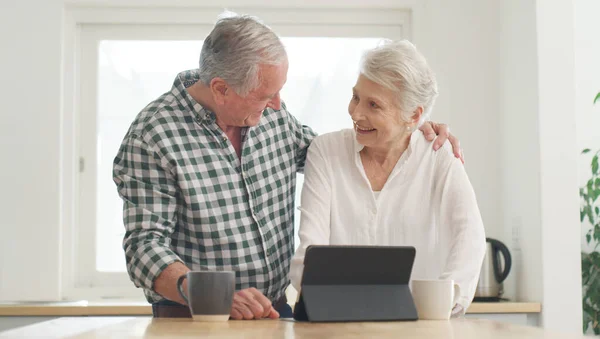 Theres nothing me miss out on thank to technology. a senior couple using a digital tablet at home