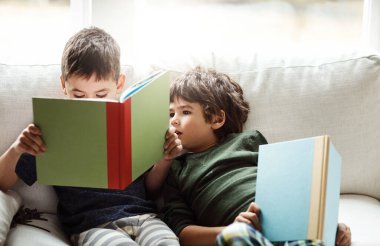 Aile hikayeyi daha da güzelleştirir. İki sevimli kardeş evde kanepede dinlenirken kitap okuyorlar.