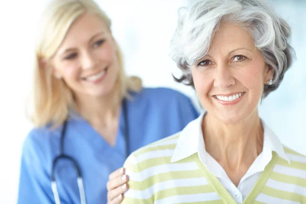 stock image Checking up on her health. Portrait of a happy senior woman visiting her doctor for a checkup