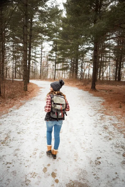 游手好闲既无目的也无理由 一个年轻女子冬季在荒野中远足的后视镜镜头 — 图库照片