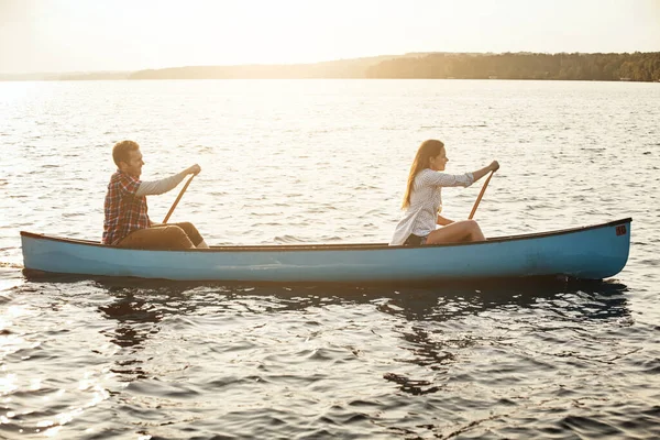 冒険のためのコースで一緒に 湖でボートを漕いでいる若いカップルが — ストック写真