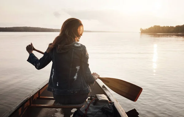 ここが平和を見つけた場所だ 湖でカヌーに乗って楽しむ若い女性のレビューショット — ストック写真