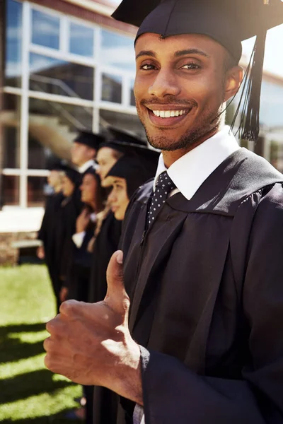 准备上毕业班 一个微笑的大学生在毕业典礼上抛出大拇指的画像 — 图库照片