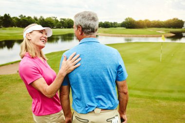 Bütün günü kalçamda bağlı olarak geçirmek. Olgun bir çift birlikte golf oynuyor.