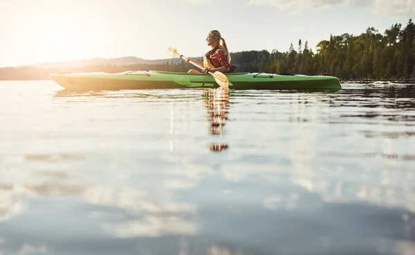 夕日は最も美しいものです 湖でカヌーに乗るための魅力的な若い女性 — ストック写真