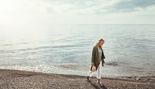 stock image Taking a chilled out stroll along the lake. a young woman spending a day at the lake