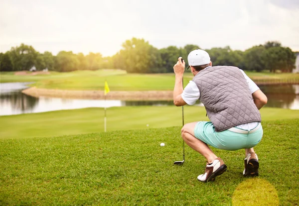 彼は緑にいる ゴルフ場でゴルフをしているハンサムな若い男の完全な長さのショット — ストック写真