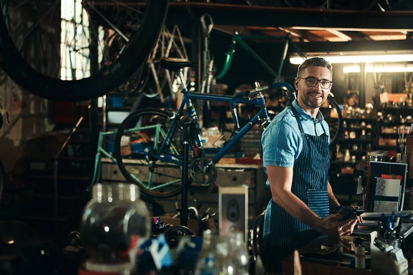 把我对自行车的热情变成了一种生意 一个成熟男子在自行车修理店工作的画像 — 图库照片