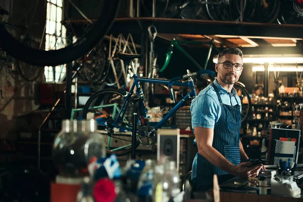你的一个停止自行车修理店 一个成熟男子在自行车修理店工作的画像 — 图库照片