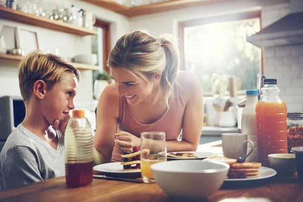 猜猜如果你吃早餐你会得到什么 当他吃早饭时 一个女人和她的儿子坐在一起 — 图库照片