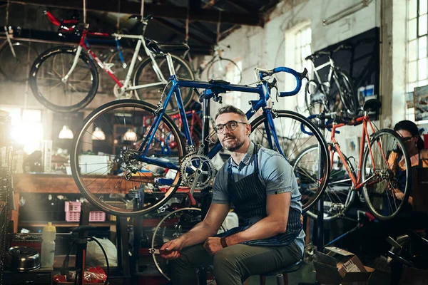 擅长任何与自行车有关的事情 一个成熟男人和他的同事在自行车修理店工作的肖像 — 图库照片