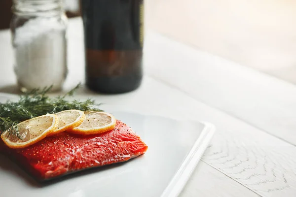 It packs a flavor and protein punch. a raw piece of meat garnished with slices of lemon