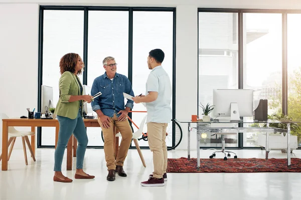 stock image Sharing some ideas. Full length shot of three creative professionals talking in the office