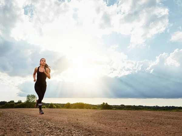 stock image Dont stop when youre tired, stop when youre done. a fit young woman out for a run on a beautiful day