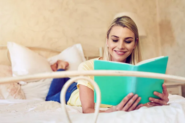 为放松而读书 躺在床上看书的年轻女人 — 图库照片