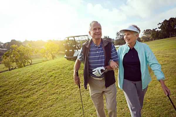 Couples golf. a smiling senior couple enjoying a day on the golf course