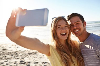 Yaz selfie 'leri. Sevecen genç bir çift sahilde selfie çekiyor.