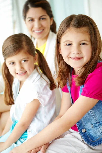 stock image Happy as can be with her family. A cute young girl spending time with her sister and mother at home