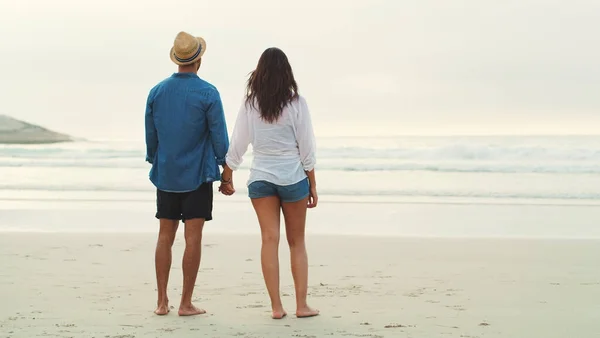 看着海浪在一起 一对深情的年轻夫妇白天在海滩上并肩散步的全景照片 — 图库照片