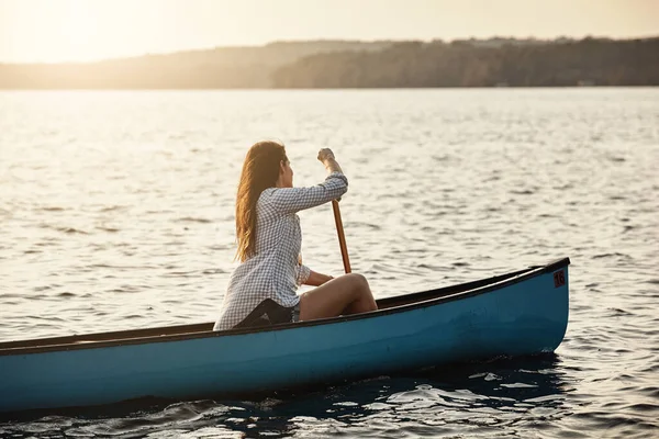抑制なしで湖を楽しむ 湖でボートを漕いでいる美しい若い女性が — ストック写真