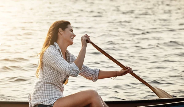 stock image Making the most of her day. a beautiful young woman rowing a boat out on the lake