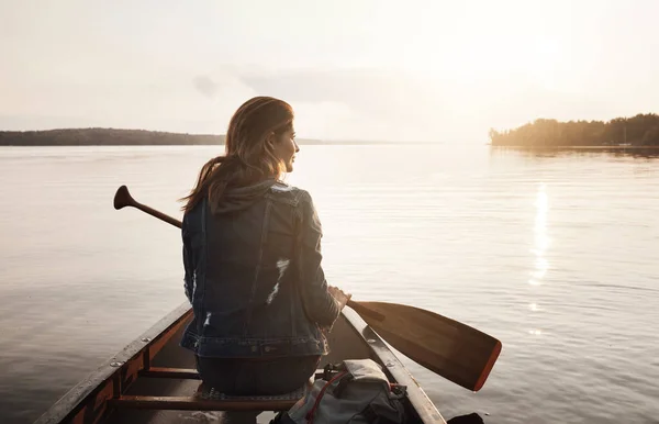 湖は彼女の脱出を見つけるところです 湖でカヌーに乗って楽しむ若い女性のレビューショット — ストック写真