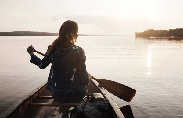 穏やかな海に沿ってパドリング 湖でカヌーに乗って楽しむ若い女性のレビューショット — ストック写真