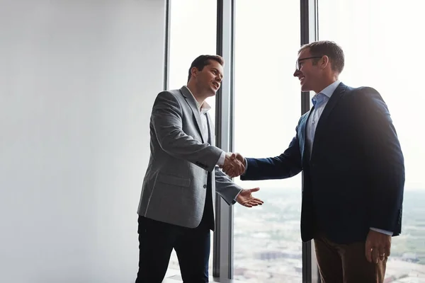 stock image And just like that, a partnership was formed. Low angle shot of two corporate businessmen shaking hands during a meeting in the boardroom