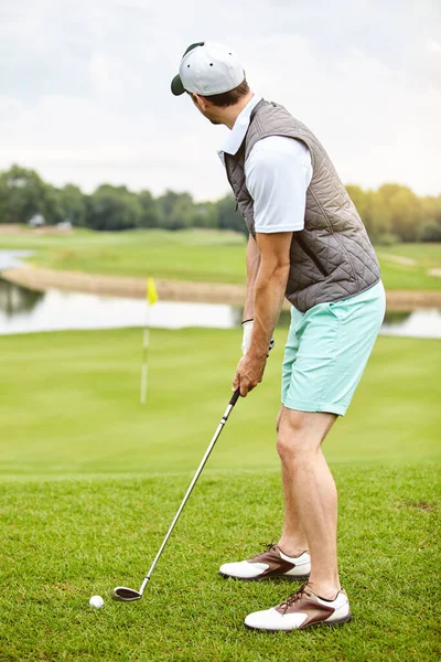 把镜头放好一个年轻英俊男子在高尔夫球场打高尔夫球的全景镜头 — 图库照片