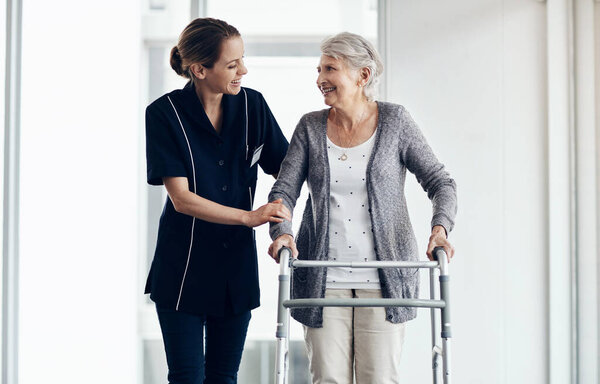 Just a kind word of support can help us rise. a female nurse assisting a senior woman using a walker