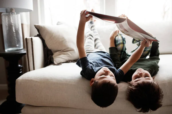 一家人幸福地生活在一起 两个可爱的兄弟一边看书 一边在家里沙发上放松一下 — 图库照片