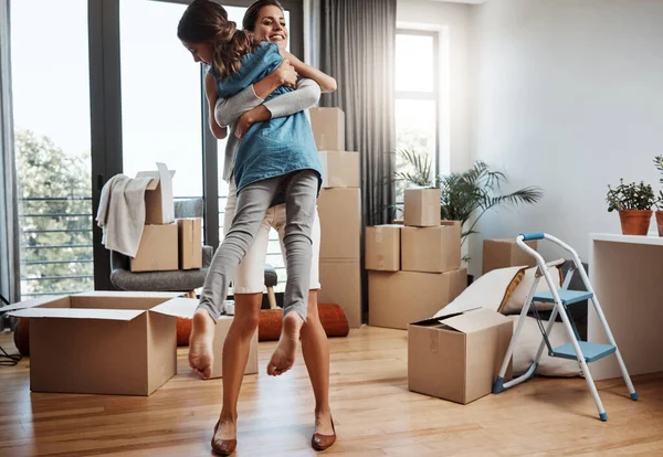 Theyre over the moon. Full length shot of an attractive young woman and her daughter dancing while moving into their new home