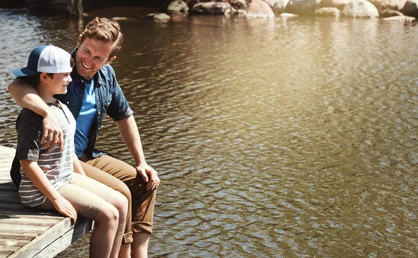 自然界で絆を育む日にほかなりません 父と息子は湖の桟橋に座って — ストック写真