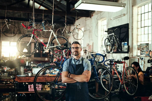努力提供优秀的自行车维修服务 一个成熟男人和他的同事在自行车修理店工作的肖像 — 图库照片