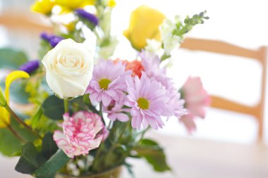 Closeup of a bouquet of flowers standing on a table. Pretty flower arrangement. Colorful pink, white, purple, yellow, green flowers and roses in a bright room for mothers day, valentines day concept. clipart