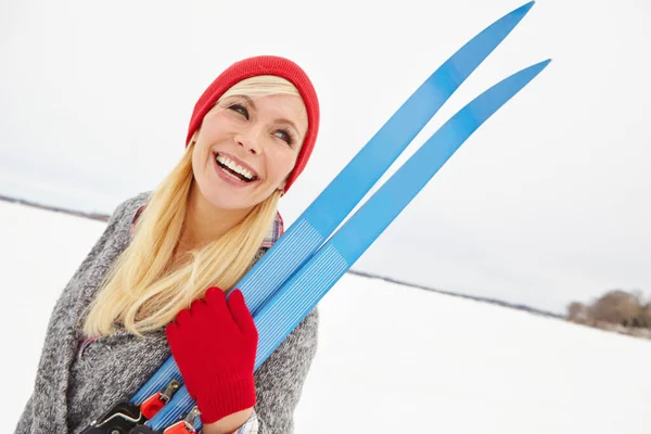 快適な冬の日に運動をしてください スキー用具を持っている若い女性が — ストック写真