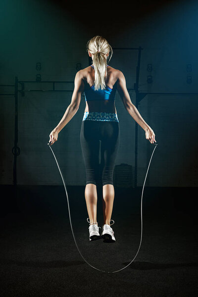 Lifes short, go rope. a young woman jumping rope in a gym