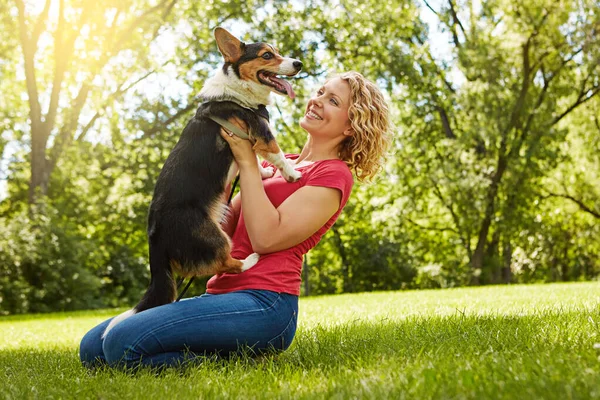 狗给予了无条件的爱的礼物 在公园里和她的狗亲近的年轻女人 — 图库照片