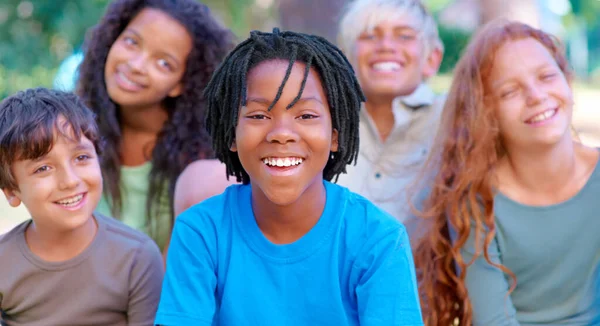 サマーキャンプの楽しみ 外に座っているとカメラに微笑む幸せな子供たちのグループ — ストック写真