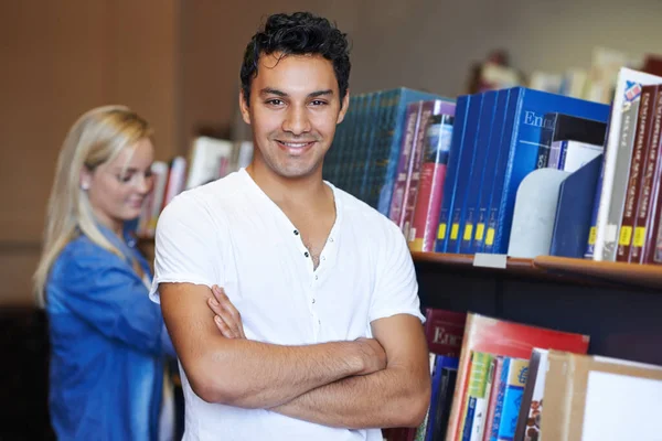 彼は大学に自信がある 図書館に自信を持って立つハンサムな若い学生の肖像画 — ストック写真