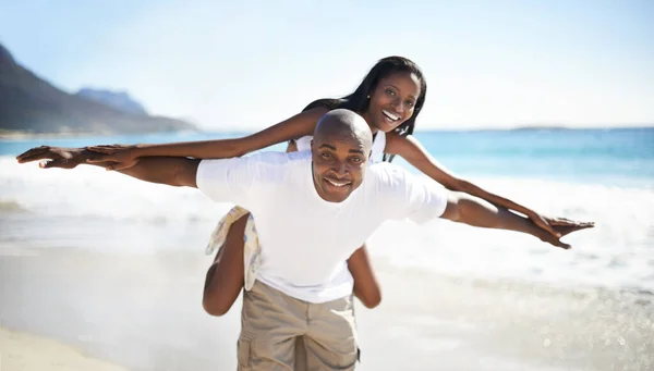 一緒に飛び立つ ビーチで彼女にピギーバックを与えるハンサムなアフリカ系アメリカ人の男 — ストック写真