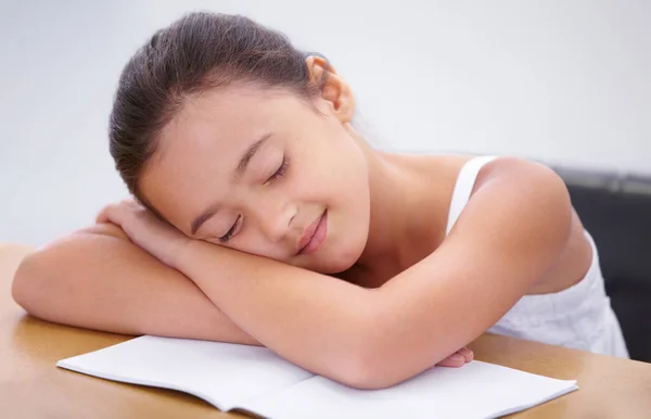 从她的学业中休息一下 一个小女孩睡在教室的书桌上 — 图库照片