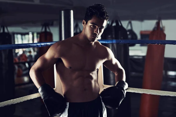 stock image Hes dedicated to the sport of boxing. Portrait of a young male boxer standing in a corner of a boxing ring