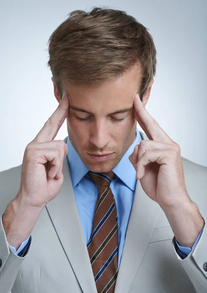 Feeling a bit stressed. a stressed businessman touching his temples