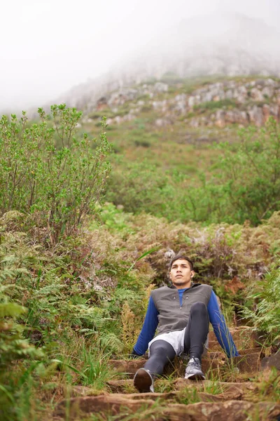 多么棒的锻炼啊 一个坐在山腰上的年轻人 — 图库照片